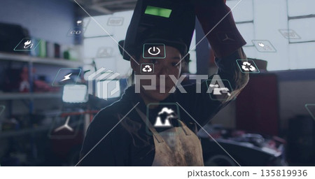 Lifting welding helmet, welder wearing apron and gloves in workshop, with tools and floating icons Lifting welding helmet, welder wearing apron and gloves in workshop, with tools and floating icons 135819936