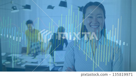 Standing Mid Adult Korean woman crossing arms smiling at table with data charts overlay, copy space Standing Mid Adult Korean woman crossing arms smiling at table with data charts overlay, copy space 135819971
