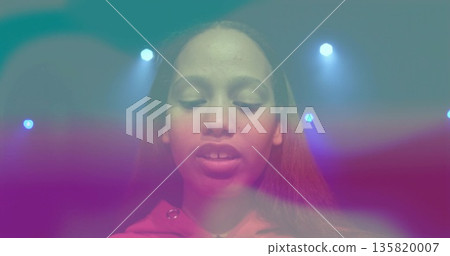 Standing teenage girl wearing red hoodie center stage, under stage spotlights and colored haze Standing teenage girl wearing red hoodie center stage, under stage spotlights and colored haze 135820007