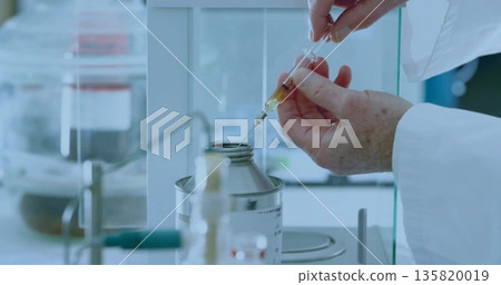 Drawing senior male hands filling syringe with amber liquid on scale under fume hood, copy space Drawing senior male hands filling syringe with amber liquid on scale under fume hood, copy space 135820019