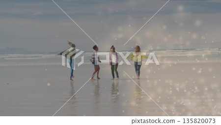 Dancing four friends wearing casual jackets and pants in shallow surf at sandy beach with sparkles Dancing four friends wearing casual jackets and pants in shallow surf at sandy beach with sparkles 135820073