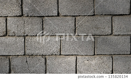 Close-up of concrete block street wall with crack in structure, cracked block masonry, textured background of large foam blocks, brick wall shrinkage and cracking 135820134