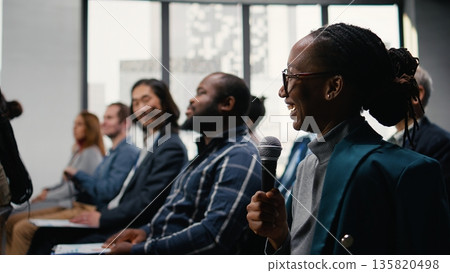 Multiethnic audience applauding and greeting presenter during discussion. Diverse white collar workers and executives attend international event, meeting in conference hall. 135820498