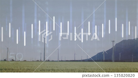 Spinning white wind turbines rotating across green field at mountain slope, with data bars faint 5° 135820820