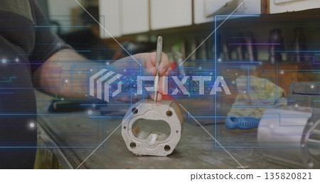 Holding pick tool technician wearing dark shirt scraping cast cylinder head at garage workbench Holding pick tool technician wearing dark shirt scraping cast cylinder head at garage workbench 135820821