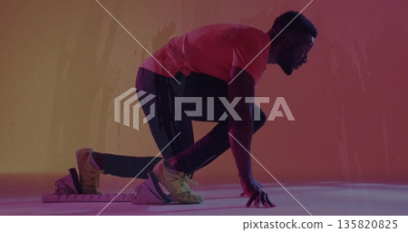 Assuming athlete planting knee on starting block and hands on floor in studio, with spiked shoes Assuming athlete planting knee on starting block and hands on floor in studio, with spiked shoes 135820825