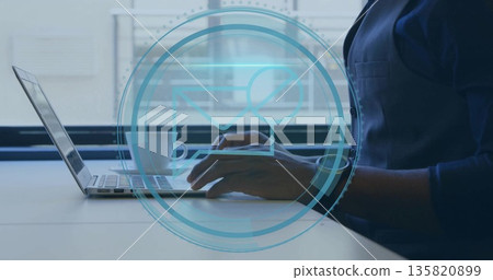 Typing worker's forearms in navy shirt at desk by window, with laptop and mug, copy space 135820899