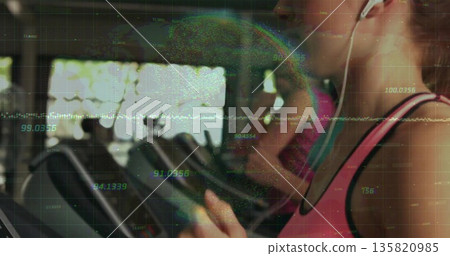 Running woman wearing pink tank top and earphones on gym treadmill with data overlay, copy space 135820985