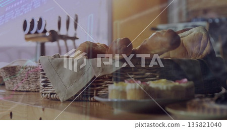 Showcasing wicker basket holding bread loaves and baguettes in bakery, with frosted cupcakes 135821040