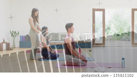 Guiding yoga participants kneeling on pink, purple mats in bright studio, with blocks and plants Guiding yoga participants kneeling on pink, purple mats in bright studio, with blocks and plants 135821102