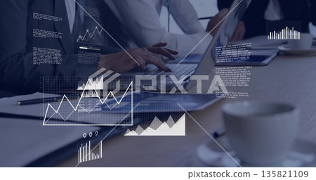 Business professionals typing and reviewing documents at conference table, with laptop, coffee cups Business professionals typing and reviewing documents at conference table, with laptop, coffee cups 135821109