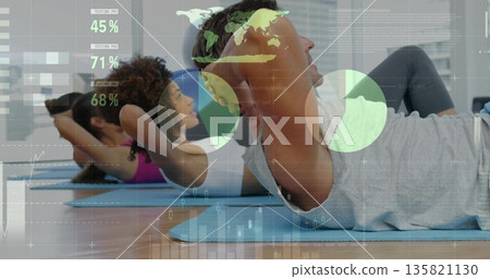 Performing abdominal crunches man wearing sportswear on blue yoga mat in studio with data overlays 135821130