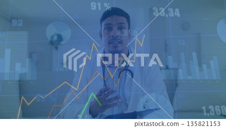 Gesturing doctor wearing lab coat, stethoscope in clinic holding clipboard with data visualizations 135821153