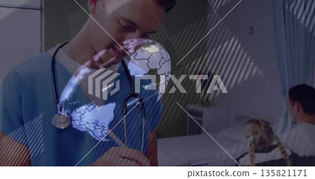 Leaning healthcare provider in scrubs writing chart in patient room, with stethoscope and globe Leaning healthcare provider in scrubs writing chart in patient room, with stethoscope and globe 135821171