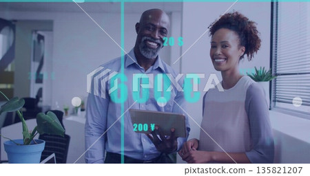 Two professionals in business attire analyzing tablet in office, with digital currency symbols Two professionals in business attire analyzing tablet in office, with digital currency symbols 135821207