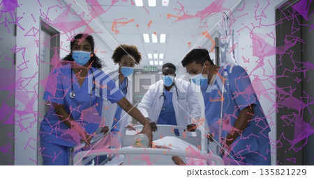 Transporting patient on wheeled stretcher by medical team moving down ward hallway IV pole showing 135821229