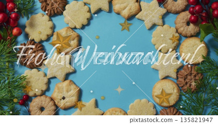 Frohe Weihnachten text image over assorted Christmas cookies on blue background 135821947