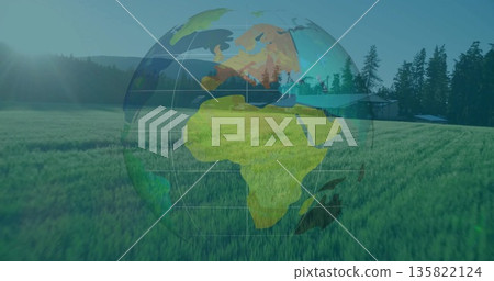 Hovering translucent digital globe overlay showing continents in meadow with pavilion and tree line Hovering translucent digital globe overlay showing continents in meadow with pavilion and tree line 135822124