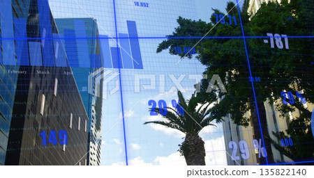 Featuring palm tree standing beside broadleaf tree in financial district, skyscrapers, data overlay 135822140