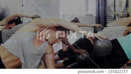 Leaning woman in grey tank top stretching side in mirrored studio, with stability ball, copy space 135822157