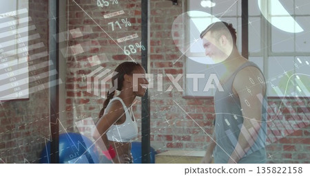 Trainer in sportswear and trainee presenting metrics in studio, digital overlay charts, blue ball Trainer in sportswear and trainee presenting metrics in studio, digital overlay charts, blue ball 135822158