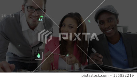 Examining jewelry pieces, coworkers in smart attire handling pendants in studio, with tweezers 135822219