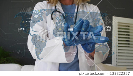 Wearing lab coat and stethoscope, doctor donning blue nitrile gloves in clinic, world map overlay Wearing lab coat and stethoscope, doctor donning blue nitrile gloves in clinic, world map overlay 135822237