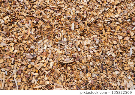 Wood chip background for garden path or recreation area covering, used as mulch or fuel. Natural texture from recycled wood. 135822509