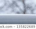 Fresh snow building up on a surface during winter with blurred trees in background creating a clean copy space 135822689