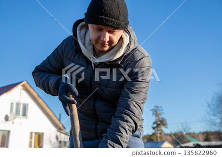 Man digging earth with shovel. Concept of gardening, farm work, or construction site for outdoor projects, physical labor. Garden work, preparing soil for planting in springtime. organic farm, field Man digging earth with shovel. Concept of gardening, farm work, or construction site for outdoor projects, physical labor. Garden work, preparing soil for planting in springtime. organic farm, field 135822960