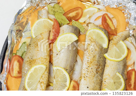 Prerape raw spiced hake for a bake in the oven with lemon, tomatoes, carrots, and onions in foil. Delicious fish for lunch or dinner, perfect for a diet. Tasty and fresh hake fish for bake with Prerape raw spiced hake for a bake in the oven with lemon, tomatoes, carrots, and onions in foil. Delicious fish for lunch or dinner, perfect for a diet. Tasty and fresh hake fish for bake with 135823126