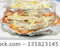 Prerape raw spiced hake for a bake in the oven with lemon, tomatoes, carrots, and onions in foil. Delicious fish for lunch or dinner, perfect for a diet. Tasty and fresh  hake fish for bake with 135823145