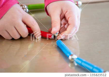 Child having fun with an authentic leisure activity, fine motor skills development 135823512