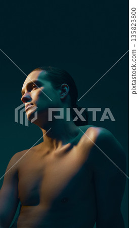 Male nude torso portrait in side light with calm expression. Male nude torso portrait in side light with calm expression. 135823800