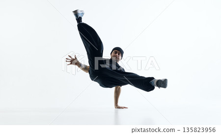 Breakdancer holding one arm freeze with extended legs isolated. 135823956