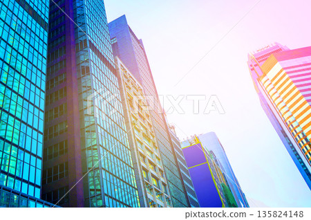 Skyscrapers bright glass exteriors sunlight on sunset. Facade office buildings in China, Hong Kong Skyscrapers bright glass exteriors sunlight on sunset. Facade office buildings in China, Hong Kong 135824148