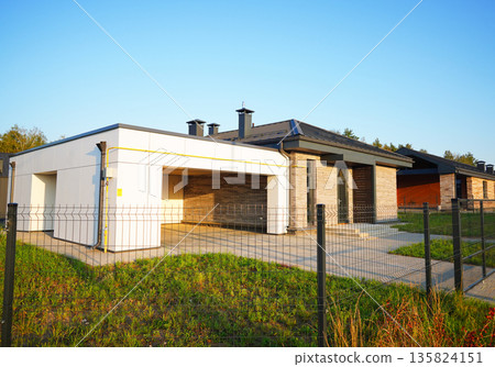 Suburban residential neighborhood, home on street, fence of single family home. Suburb family house Suburban residential neighborhood, home on street, fence of single family home. Suburb family house 135824151