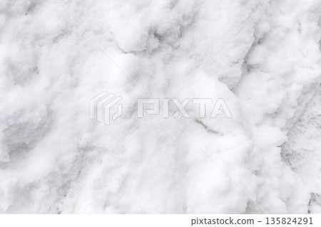 Soft snow blankets the ground in a winter scene. The snow is untouched, creating a smooth white surface. This setting invites activities like snowball fights and snowman building 135824291