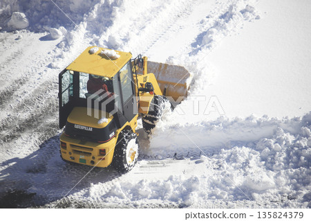 除雪車正在清理積雪覆蓋的停車場 除雪車正在清理積雪覆蓋的停車場 135824379
