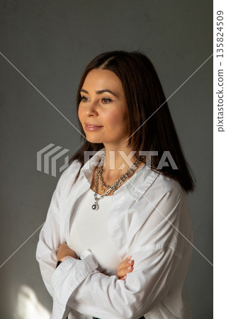 Confident woman with arms crossed in studio setting, in white shirt on dark background in professional atmosphere. Business portrait of interior designer, businesswoman, successful woman 42 years old Confident woman with arms crossed in studio setting, in white shirt on dark background in professional atmosphere. Business portrait of interior designer, businesswoman, successful woman 42 years old 135824509