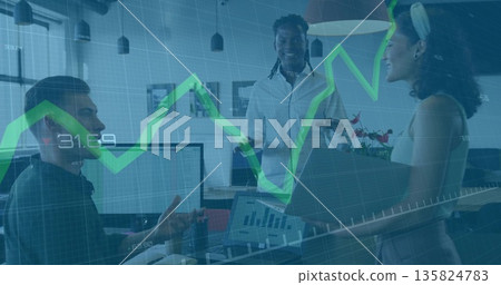 Collaborating team analyzing charts on laptop and monitors in open-plan office, growth overlay 135824783