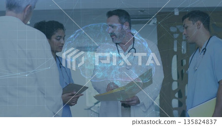 Standing patient in jacket and staff in scrubs examining brain hologram in clinic hall, with tablet 135824837