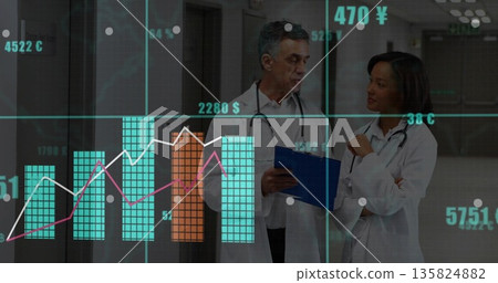 Medical professionals in lab coats reviewing digital charts in hospital hallway, with stethoscopes Medical professionals in lab coats reviewing digital charts in hospital hallway, with stethoscopes 135824882