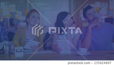 Sitting coworkers holding tablets and notebooks in modern office, with coffee cup and sticky notes 135824897