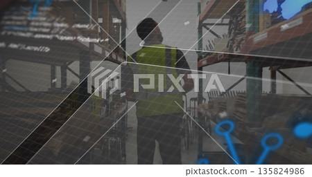 Walking warehouse worker wearing safety vest inspecting steel shelving with boxes under gridlines Walking warehouse worker wearing safety vest inspecting steel shelving with boxes under gridlines 135824986