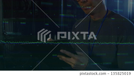 Monitoring data overlays, Korean IT tech with lanyard tapping tablet among server racks, copy space Monitoring data overlays, Korean IT tech with lanyard tapping tablet among server racks, copy space 135825019
