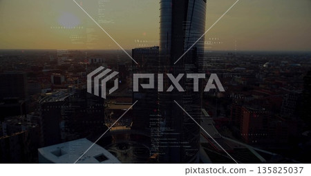 Twin cylindrical glass towers gleaming in dusk skyline, with lit street grid and code overlays 135825037