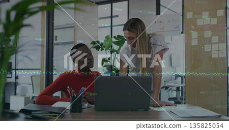 Collaborating coworkers in red sweater, white blouse editing document at office desk, with laptop Collaborating coworkers in red sweater, white blouse editing document at office desk, with laptop 135825054