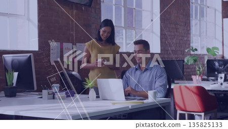 Typing male colleague using laptop at open-plan office desk, with coworker holding coffee mug Typing male colleague using laptop at open-plan office desk, with coworker holding coffee mug 135825133