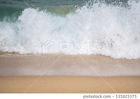 Ocean waves crashing on sandy beach Ocean waves crashing on sandy beach 135825373